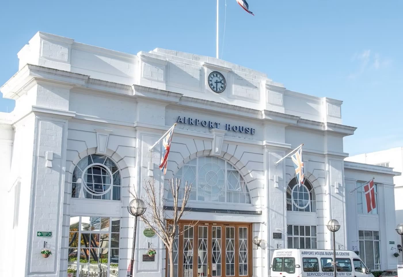 The white art deco frontage of Airport House on Purley Way, Croydon, with its clock and flagpoles.